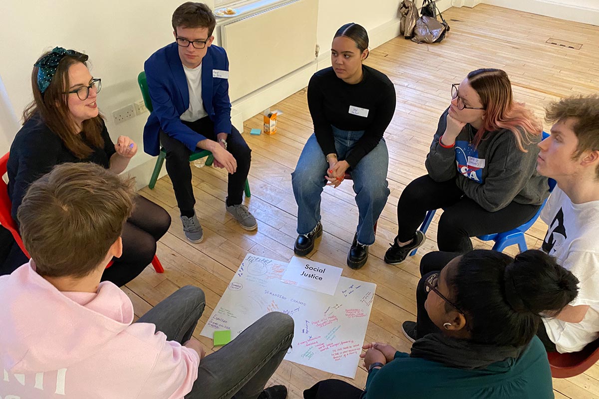 Group of young people sitting on chairs in a circle