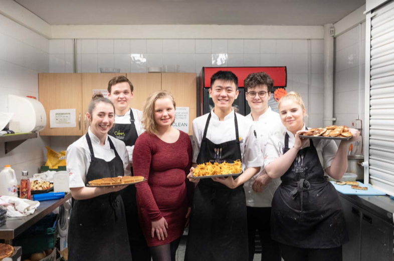 bethan and the chefs presenting the food they prepared