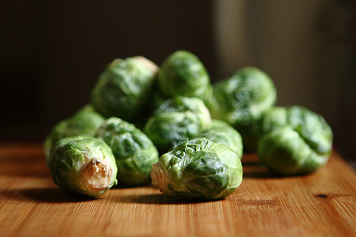 A pile of Brussel sprouts on a wooden table