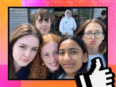 A group of five girls huddled closed together taking a selfie, Lilla is in the middle of the photo with curly red hair and wearing purple eyeshadow