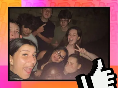 A group of young people taking a selfie with flash light on in a dark environment 