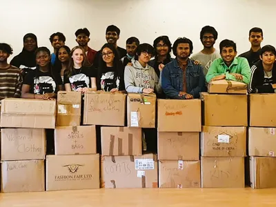 group of young people standing behind boxes