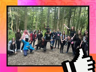  A group of young people smiling and posing together for a photograph amidst a lush green forest backdrop.