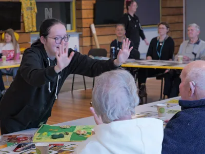 Summer wearing a black hoodie with glasses leaning forward and stretching her two hands forward in a demonstration mode.  