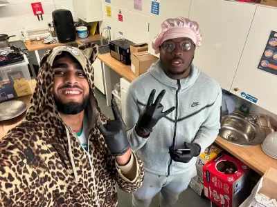 An NCS team leader on the left with a leopard skin onesie and on the right, a young male wearing a grey jumper with a pink bonnet.