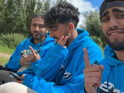 Three NCS team leaders wearing a light blue NCS hoodie.