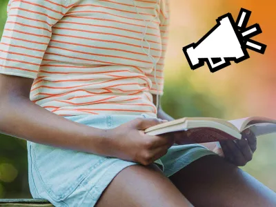 A person sitting down holding an open book