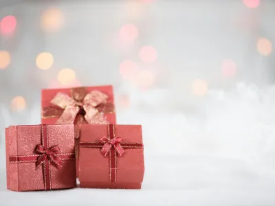 Three red gift boxes wrapped with bows on the middle of each of them. .  