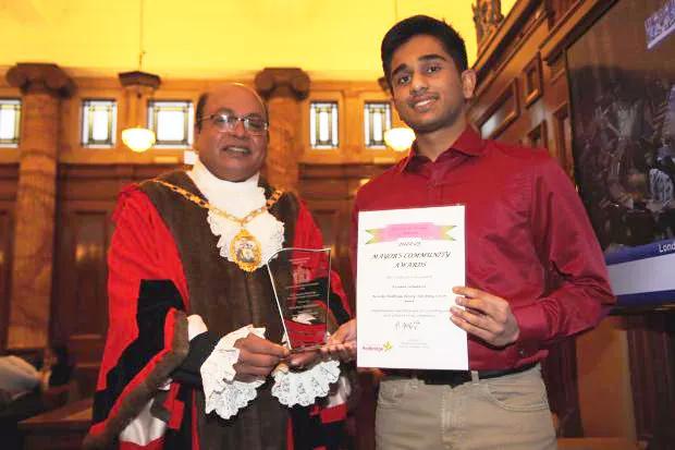 Kirushan is stood next to the Mayor holding a certificate and award for the Mayor's community award.